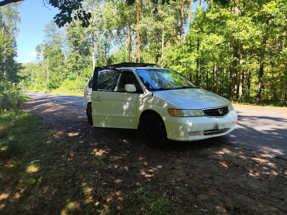 Minivan camping with open sliding door and camping gear setup