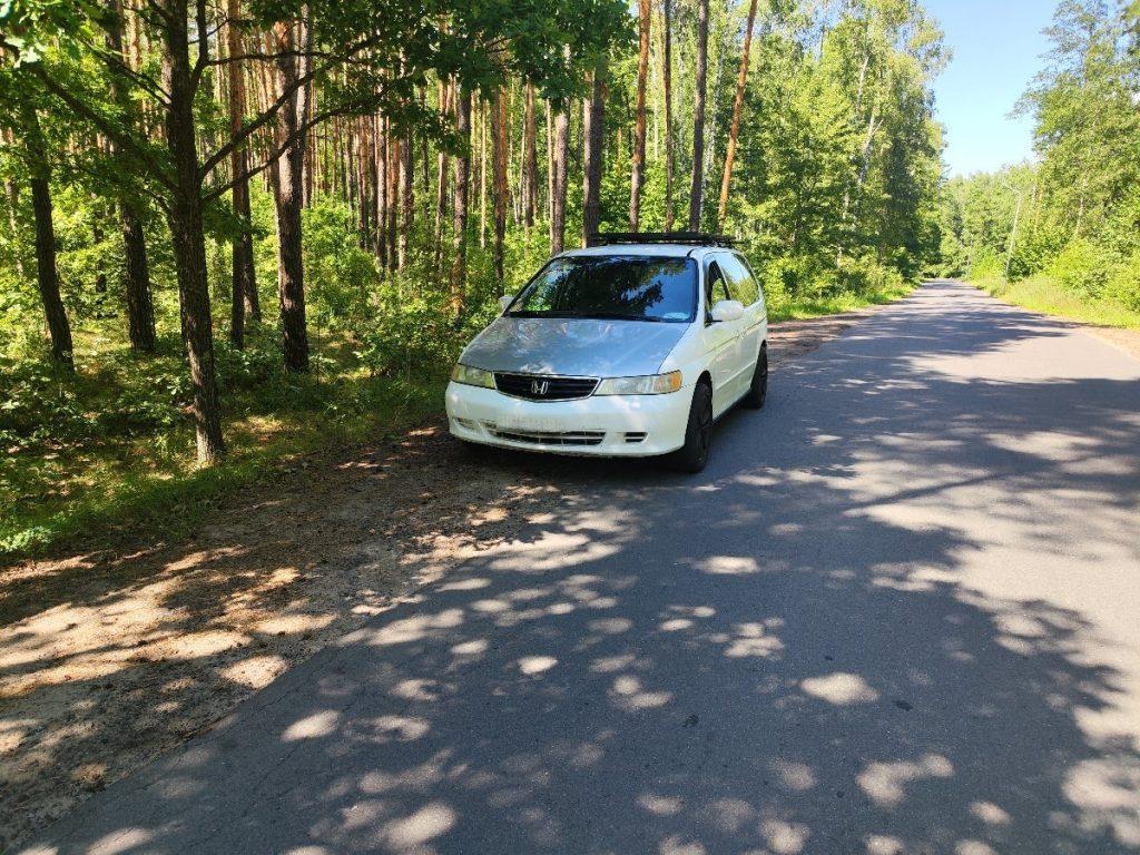 Honda Odyssey side view with roof rack in forest clearing