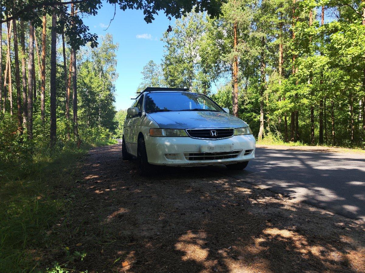 Honda Odyssey parked on forest road side profile with roof rack